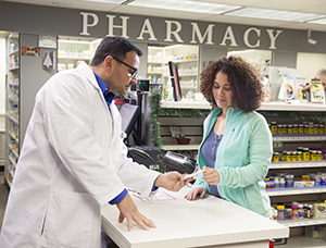 Pharmacist talking to woman at pharmacy counter.